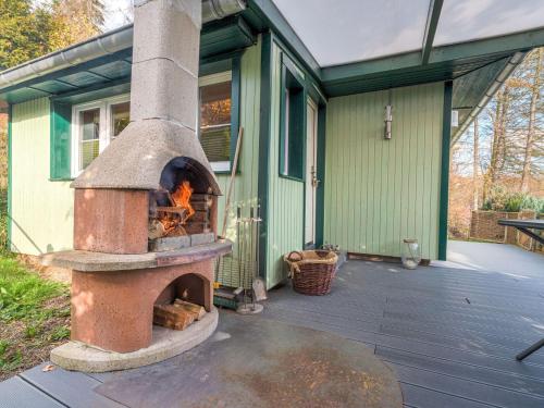 un horno de ladrillo sentado fuera de una casa en Holiday home with terrace next to the forest, en Allrode