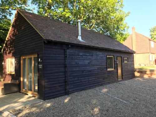 een klein houten gebouw met een garage bij Northdown Lodge - Stunning property on the Kent Northdowns in Hollingbourne