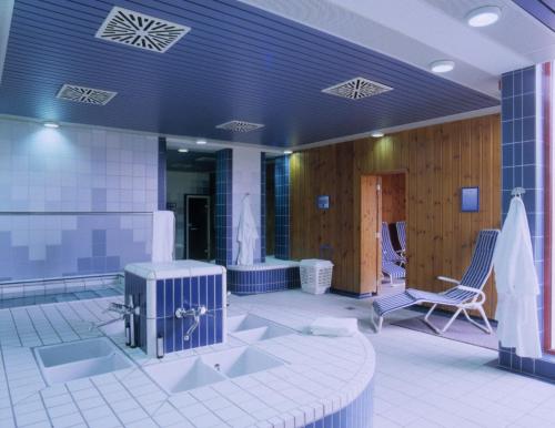 a bathroom with two sinks and a bath tub at Hessen Hotelpark Hohenroda in Hohenroda