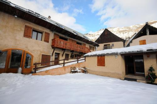a snow covered yard in front of a building at Résidence - Gite La Mourée in Vars