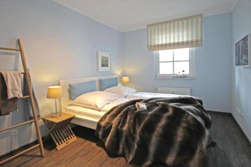 キュールングスボルンにあるHaus-Atlantik-Wohnung-3-16-98のベッドルーム1室(毛布付きのベッド1台付)