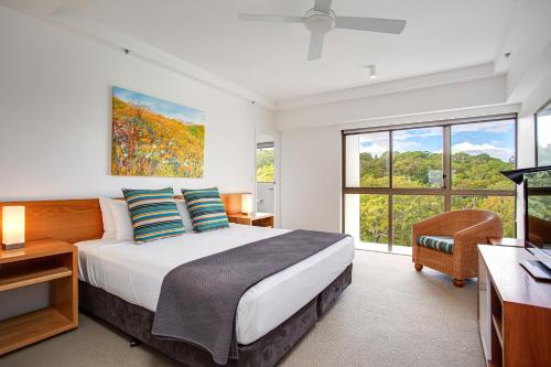 a bedroom with a large bed and a large window at Gemini Court Holiday Apartments in Gold Coast