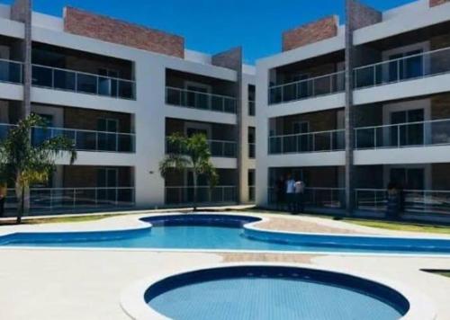 an apartment building with two pools in front of a building at Varandas do Francês in Maceió