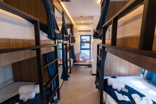 a room with three bunk beds in a dorm room at UNWND Boutique Hotel Makati in Manila