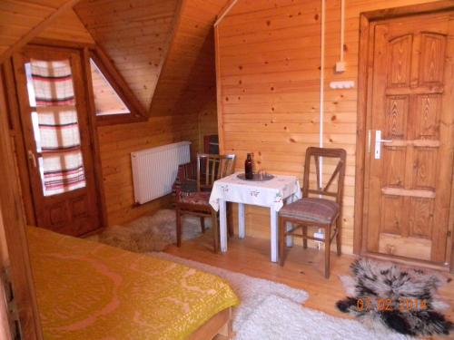 una habitación con mesa y sillas en una cabaña en Küküllő Vendégház, en Sovata