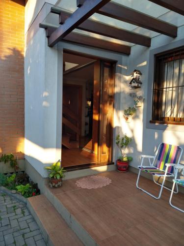 un patio con 2 sillas en una terraza de madera en Casa Compartilhada en Canela