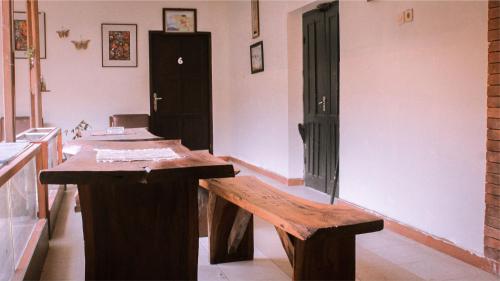a room with a wooden table and a bench at nDalem Joglo Krawitan Syariah in Yogyakarta