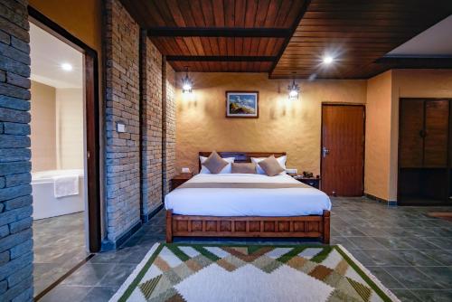 a bedroom with a large bed in a room with a tub at Bar Peepal Resort in Pokhara
