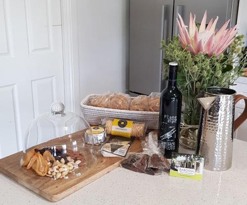 a cutting board with a bottle of wine and some food at Barossa Bed & Breakfast in Tanunda