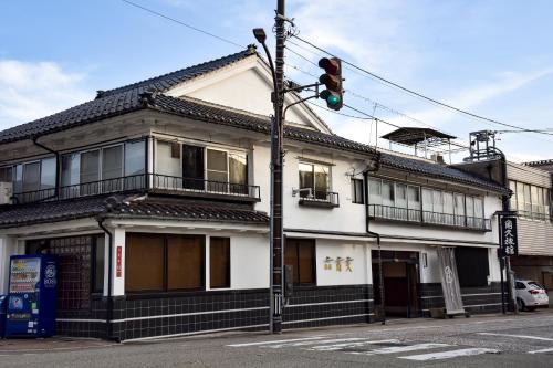 a green traffic light in front of a white building at Kadokyu Ryokan in Takaoka
