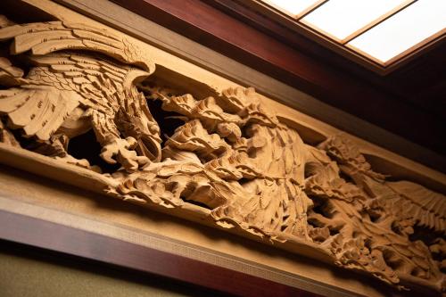 a wooden carving of a dragon on a wall at Kadokyu Ryokan in Takaoka