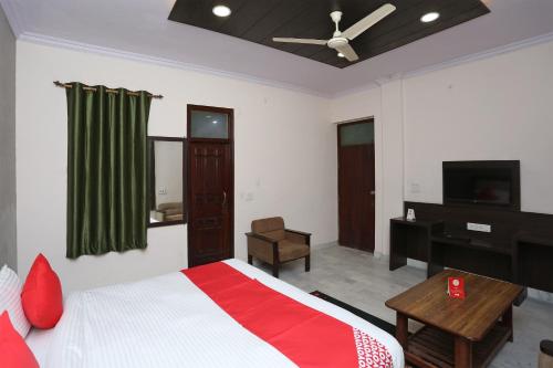 a bedroom with a bed and a desk and a ceiling fan at Hotel Maharana Palace in Mathura