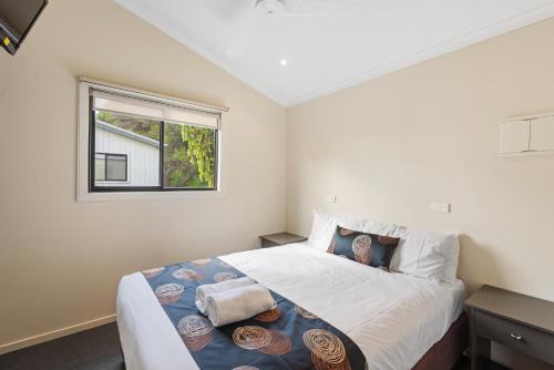 a bedroom with a large bed with a window at Discovery Parks - Geelong in Geelong