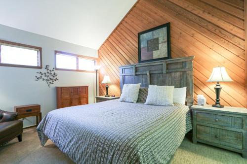 1 dormitorio con 1 cama grande y pared de madera en Aspen Creek #306 Condo, en Mammoth Lakes