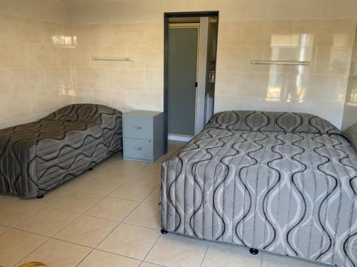una camera con 2 letti e un pavimento piastrellato di Top 1 Motel a Rockhampton
