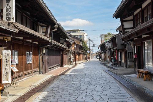 a cobblestone street in an old town with buildings at Kadokyu Ryokan in Takaoka