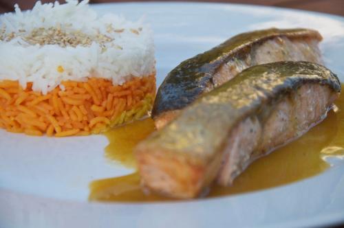 a plate of food with rice and meat and a pickle at Ino Hotel & Suites in Samos