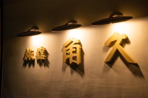 a group of signs on a wall with lights at Kadokyu Ryokan in Takaoka
