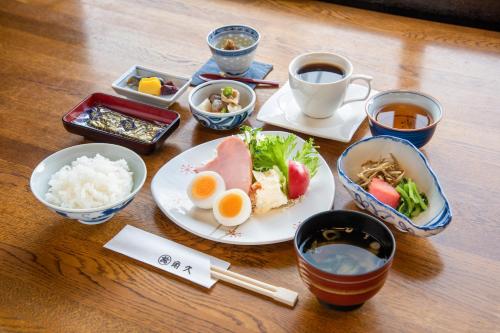 a table with plates of food and cups of tea at Kadokyu Ryokan in Takaoka