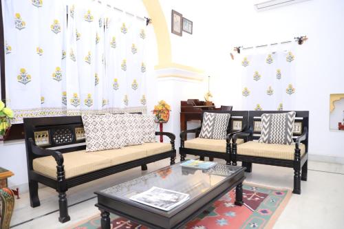 a living room with three couches and a table at Rawla Bisalpur in Jawāi Bāndh