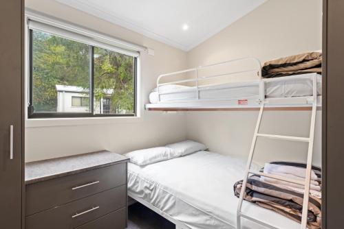 a bedroom with two bunk beds and a window at Discovery Parks - Geelong in Geelong