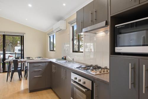 a kitchen with a sink and a stove top oven at Discovery Parks - Geelong in Geelong