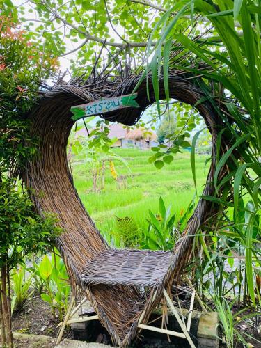 a wicker chair with a sign in a garden at KTS Balinese Villas in Canggu