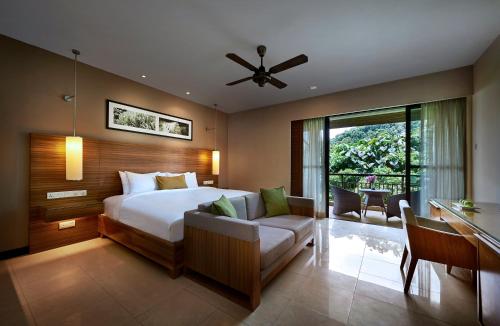 a bedroom with a bed and a desk and a couch at The Taaras Beach & Spa Resort in Redang Island