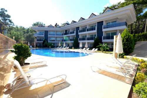 een resort met een zwembad en ligstoelen bij Truemar Hotels & Suites in Kemer