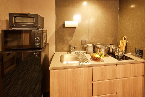 a kitchen with a sink and a microwave at MONday Apart Premium AKIHABARA in Tokyo