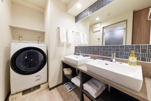 a bathroom with two sinks and a washing machine at MONday Apart Premium AKIHABARA in Tokyo