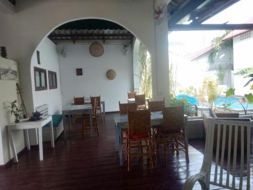 a dining room with chairs and a table and a table and chairs at Manoha Villa in Sihanoukville