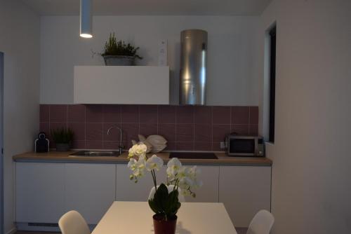 a kitchen with a table with a vase of flowers on it at Villa Alcova in Caorle
