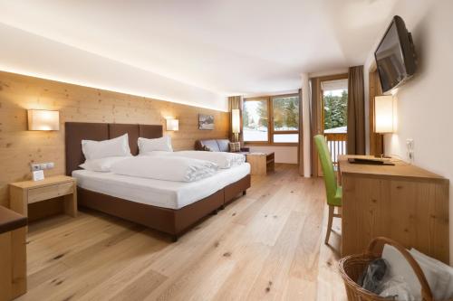 Habitación de hotel con cama y TV en Sporthotel Floralpina, en Alpe di Siusi