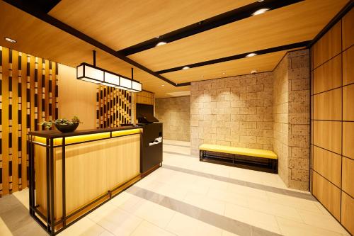 a lobby with a yellow bench in a building at MONday Apart Premium AKIHABARA in Tokyo