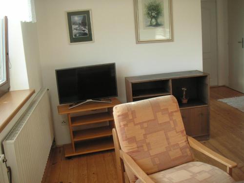 uma sala de estar com uma cadeira e uma televisão em Prázdninový dům Cihelna em Strmilov