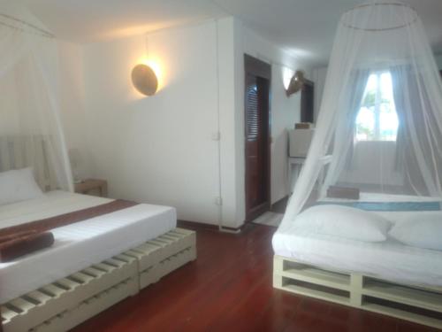 a bedroom with two beds and a swing at Manoha Villa in Sihanoukville