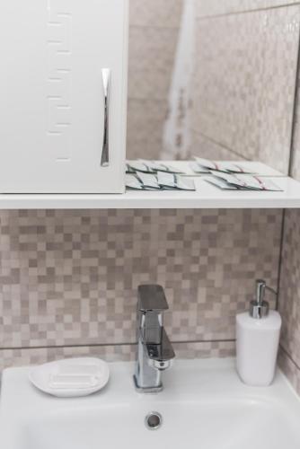 a bathroom sink with a faucet on a counter at Hotel Voyage Вояж in Umanʼ