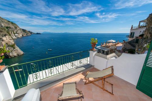 a balcony with two chairs and a view of the ocean at Hotel Onda Verde in Praiano