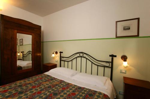 a bedroom with a bed and a large mirror at Le Camere Di Paolino in Manciano