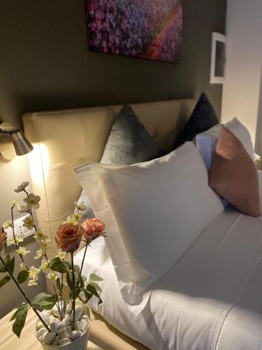 a bed with pillows and a table with a lamp at Lo Stallone -Malpensa Milan airport in Buscate