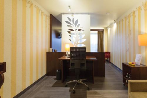 an office with a desk with a computer on it at Wellness-& Nationapark Hotel Schliffkopf, BWSC in Baiersbronn