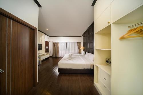 a hotel room with a bed and a bathroom at The Wing Lanna Hotel in Chiang Mai