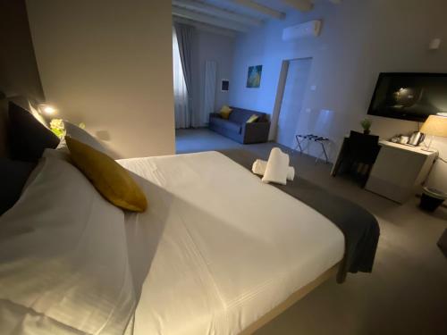 a bedroom with a large white bed and a living room at Lo Stallone -Malpensa Milan airport in Buscate