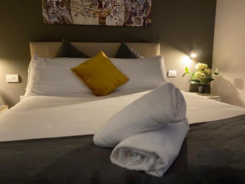 a bed with a white blanket and a yellow pillow at Lo Stallone -Malpensa Milan airport in Buscate