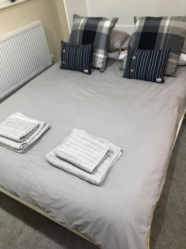 a bed with two towels sitting on top of it at M60 Modern Studio Appartment with free parking in Denton