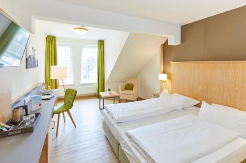 ein Hotelzimmer mit einem Bett und einem Schreibtisch in der Unterkunft Landgasthof Hotel Hess in Neuenstein