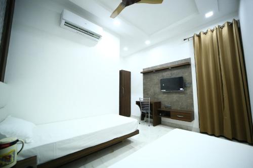 a hotel room with a bed and a television at Hotel Byke Ride - Walkable from Agra Cantt Railway Station in Agra