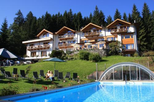 um hotel numa colina com piscina em Gartenhotel Rosenhof bei Kitzbühel em Oberndorf in Tirol