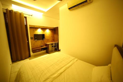 a hotel room with a bed and a television at Hotel Byke Ride - Walkable from Agra Cantt Railway Station in Agra